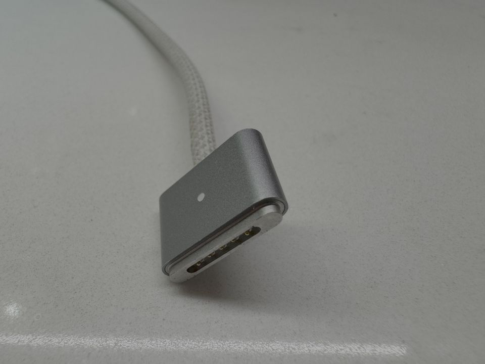 MagSafe 3 단자와 위쪽 표시등 위치. 케이블 끝의 접점이 보인다.